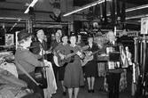 Frälsningsarmén spelar musik och sjunger på Domus varuhus vid Frölundagatan i Mölndals centrum, år 1983.

Fotografi taget av Harry Moum, HUM, för publicering i Mölndals-Posten, vecka 49 1983, med bildtexten:


