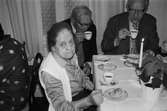 Greggered kapell i Lindome, år 1983. En äldre kvinna och två äldre män dricker kyrkkaffe efter gudstjänsten.

För mer information om bilden se under tilläggsinformation.