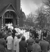 Konfirmation i Ljusnarsbergs kyrka, konfirmander, präst och människor utanför kyrkan.