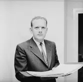 Kontorsinteriör, en man med en pärm.
Wofors