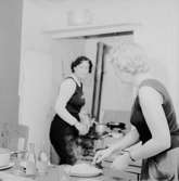Skådespelarna hemma hos Helmer Linderholm.
Två kvinnor i köket.