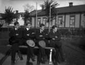 Grupp fyra pojkar.
I bakgrunden den s.k. Rubinska gården,  på söder på Kungsgatan i Lindesberg.