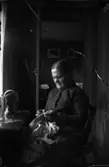 Rumsinteriör, en kvinna vid symaskinen.
Eva Sofia Pettersson (givarens farmor).