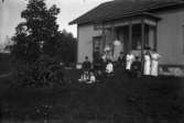 Bostadshus, släktgrupp, bl.a. Eva Sofia Pettersson (givarens farmor) till höger på verandan. (Även några av givarens fastrar finns med på bilden).
Bilden troligtvis tagen i Öskevik.