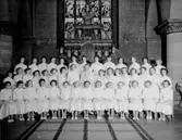 Konfirmander, 42 flickor och prosten Benny Benktsson.
Interiör av Nikolaikyrkan.
Flickor från Läroverket, Kommunala Flickskolan och Praktiska Realskolan.