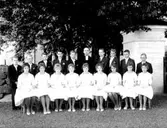 Konfirmander, 9 flickor, 9 pojkar och kyrkoherde Ragnar Wilhelmsson, vikarie för kyrkoherde Gunnar Johansson (som var sjuk).
Glanshammars kyrka.