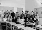 Klassrumsinteriör, 37 skolbarn med lärarinna.