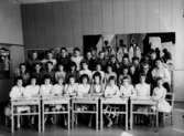 Klassrumsinteriör, 33 skolbarn med lärarinna.