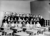 Klassrumsinteriör, 30 skolbarn med lärare.