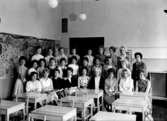 Klassrumsinteriör, 27 flickor med lärarinna.