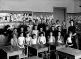 Klassrumsinteriör, 24 skolbarn med lärarinna.