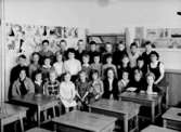 Klassrumsinteriör, 28 skolbarn med lärarinna.