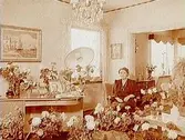 Byggmästare Arvid Erikssons fru på 50 årsdagen.
Rumsinteriör, en kvinna.