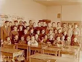 Olaus Petriskolan, klassrumsinteriör, 37 pojkar med lärare Per-Erik Månsson, klass 4A, sal 38.
Elever på bilden: Benny Wind, Jan Andersson, Urban Hidman, Jan Folkesson, Åke Halldin, Jernberg, Rutger Ahlbeck, Rolf Israelsson, Pålsson, Mats Johansson (ändrade senare namn till Mats Lindman), Leif Byström, Erik Atterhed, Björn Scholterus, Mats Rönsen, S-O Svensson, Niklas Lapukins, Lars Svensson (?),  och den underbare läraren Per-Erik Månsson.