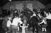 Lindome hembygdsgilles julgille på Hällesåkersgården i Lindome, år 1984. Dans kring granen.

För mer information om bilden se under tilläggsinformation.