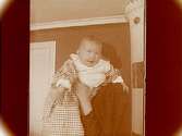 En liten flicka (med barnsköterskan?).
Maj Thermaenius (född den 18 oktober 1908).