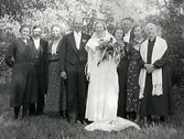 Strömma, Tvååker. Brudpar med bröllopsgäster. Brudgum August Johansson, brud Ester Andersson. (Vigselförrättare kyrkoherde Ernst Sjöblom, Varberg). Längst t h brudgummens mor Lovisa Karlsdotter, Sjöö. Bakom henne möjligen en dotter. Bakom dessa Algot Bengtsson och h h Julia Olsson, Tyllered 2. Längst t v Junis Börjesson, Getakulla, gift Svensson. Vid hennes sida möjligen brudens far Anders Karlsson. Därefter brudens mor Matilda Bengtsdotter.