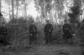 Fyra soldater (fyra män i uniformer, med vapen).
Se även bild 2008:35:106.