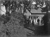 Bostadshus, grupp fem personer framför huset.