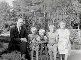 Foto av Hjalmar Magnusson med familj. Bilden är tagen utomhus. Från vänster: Hjalmar Magnusson, barnen; Iris Magnusson, Tore Magnusson, Lilian Magnusson och hustru Judit Magnusson.