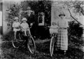 Familjegrupp fem personer med två cyklar.
Bostadshus i bakgrunden.
Ernst Gustafssons syster och svåger.