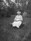 En kvinna sittande på en bänk.
Dalarna.