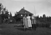 Tre kvinnor. Bostadshus i bakgrunden.Dalarna