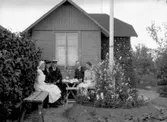 Örebro kolonien.
Bostadshus, fem personer vid kaffeborddet, framför huset.