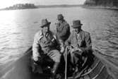 Motorbåtsfärd på Stora Trehörningen, tre män och en hund.
Eric von Rosen, Jägmästare Söderström med taxen, Herbert Löfstrand styr.