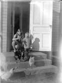 Gården Karlshem i Västerås-Barkarö.
Bilden visar syskonen Britta och Anders på trappan till huset Margretehill i Norberg dit givaren och hans föräldrar och syskon flyttade 1926. I lådan där glasplåten påträffades fanns skrivet: 