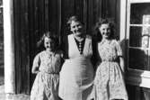 Familjegrupp tre personer (en kvinna och två flickor) framför huset.
Fru Linnéa Almqvist med döttrarna Doris och Verna.
Skyttatorp