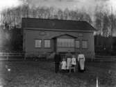 Familjebild. Familj fotograferad utanför villa.