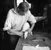 Hattillverkning. 212/67 Med en sax klippes allt överflödigt tyg bort.