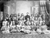 Skolfoto. Skolklass från Folkskolan i Varberg 1909. Lärarinnan Olivia Andersson i bakre raden.