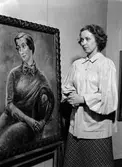 Märta Grünewald vid en av Isaac Grünewalds målningar, konstutställning på Östgöta nation, Uppsala 1943