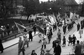 V-dagen, den första egentliga fredsdagen. Studenttåget har just passerat Skytteanska valvet på väg mot Universitetshuset, Uppsala 8 maj 1945