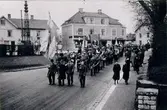 Mössebergs musikkår. Invigning av skjutbanan vid Bestorp. Vid Trekanten, korsningen S:t Olofsgatan och Scheelegatan 1941. Klarinett Arvid Pompeijus, tenorbasun John W. Gustavsson, trumpet Olle Karlsson, för övrigt syns Arnold Ewerts, Oskar Nilsson, Karl-Erik Gustavsson (Juten) och Rune Olofsson.