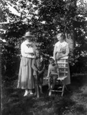 På Veken. Ester Nilsson med sonen Olle. Till höger Hilma på Veken. Okänd pokje. Olle har Hilmas näverkur som hon blåste i kl. 4 varje eftermiddag.