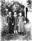 Familjen Palmqvist i Bragnum. Johan P, dottern Elin, hustrun Anna (född 1875, hon blev 99 år). Medaljen på Johans rockuppslag är från Tomtens kalkbruk.