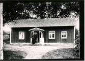 E. Karlsson och hans fru på trappan till sitt hus.