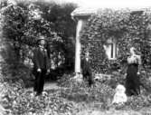 Österås. Emil, Ejnar och Nenny Gustavsson och hennes son Gösta född 1918. Baksidan av huset.