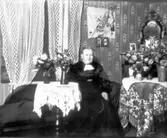 Troligen barnmorksan Carolina Söderlund, kanske på 60-årsdagen 1933. Hon avled 1935. På väggen USA:s flagga, kan vara från dottern Ingeborg som emigrerat.