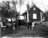 Nybloms gamla hus på Lövängsgatan 5. T.v. ladugården, t.h. Bäckadalen. Artur, Helfrid och Samuel Nyblom.