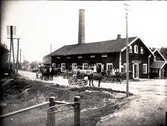Floby mejeri omkring 1924. På lastbryggan Ragnar Sundström, John Hermansson, mejerskan Hulda Fält och mejeristen Friberg. Huset till höger Hofflanders möbelaffär, husen till vänster Qvissle kraftbolags kontor och Godtemplarlokalen. Torsten i Bonnagården vid främre hästskjutsen.