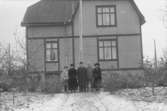 Bostadshus, familjen Lindbergs villa. Familjen Lindberg fem personer framför huset.