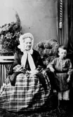En kvinna och en liten pojke.
 Prostinnan Christina Margareta Wikander, född Svenberg ( född 1786-06-01, död 1864-02-06) och Emil Adlers, född 1858 i Norra Yxhult, Kumla, Örebro län, död 1936 i Örebro.
Christina Margareta Svenberg var född 1786-06-01 i Tossene i Bohuslän, död 1864-02-06 på Köpmangatan 21 i Örebro.
Hon var gift först med med Carl Eric Hallgren i Stora Malm.
Gift andra gången med Per Wikander från Vintrosa, prost i Knista.
Dottern hette Juliana Christina Wikander, gift Adlers, mor till Emil Adlers (pojken på bilden).
Margareta har genom tiderna stavats  Margeta, Margreta eller Margareta, med eller utan h. Kyrkoskrivaren stavade som han tyckte såg bra ut.