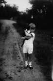 En liten pojke med en katt i famnen.
Stig Karlsson, född 1924.