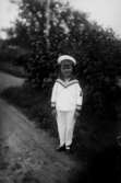 En liten pojke i sjömanskostym.
Stig Karlsson, född 1924.