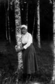 En flicka vid en träd.
Berta Lindgren