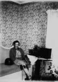 Rumsinteriör, en flicka.
Karin Eklöf lyssnar på radion.
Bilden tagen i slutet av 1930-talet.
